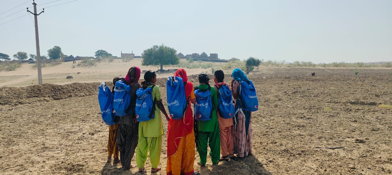 A group of people in Barmer India carrying the WaterSafe backpacks, aiding Barmer, India. 
